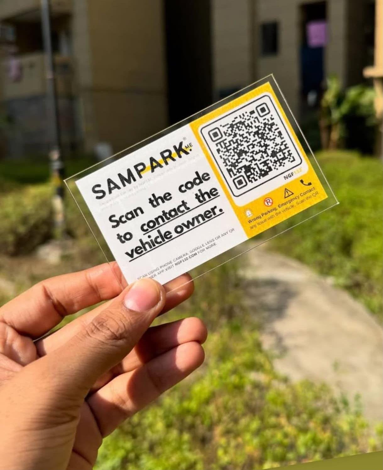 Sampark QR vehicle tag — transparent physical product held in hand